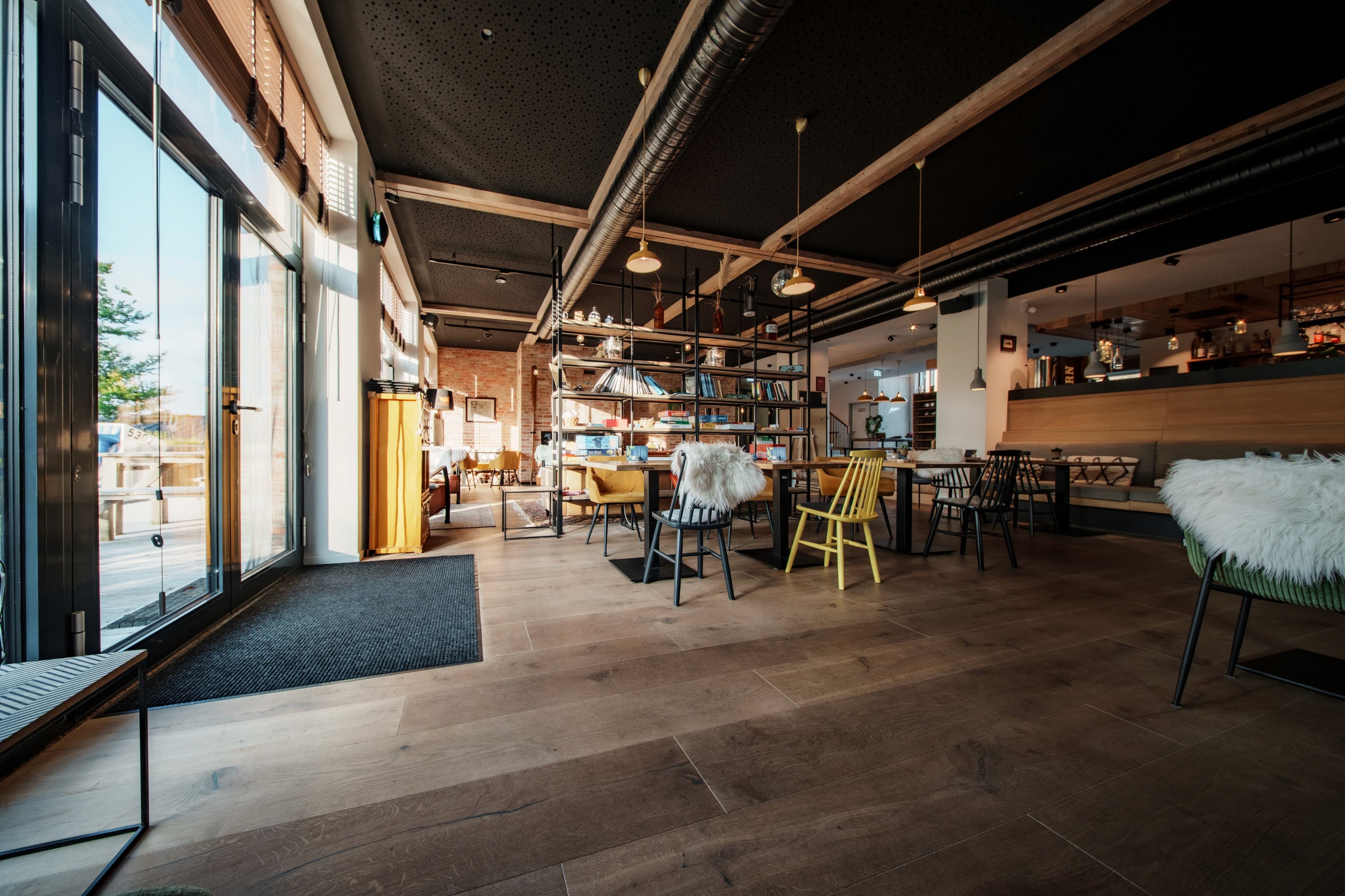 Modernes Café-Interieur mit Holzboden und Industrial-Decke