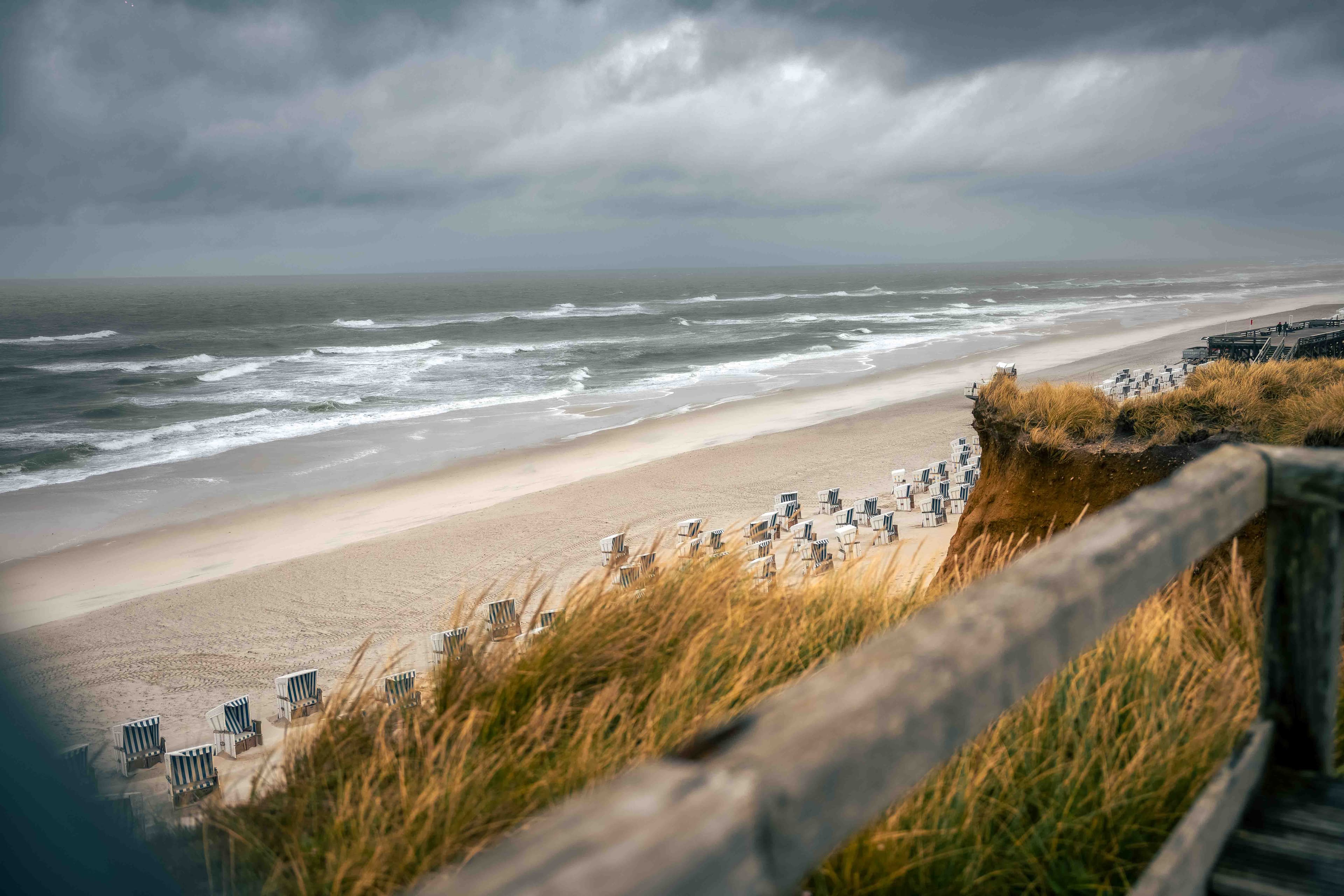 Strand von Sylt mit Strandkörben bei dramatischem Himmel
